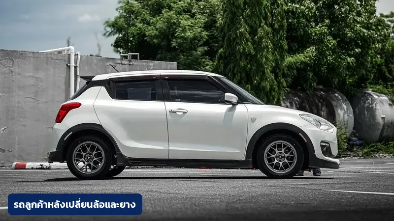 รถ Suzuki Swift ของลูกค้าร้าน TAIRODGROUP หลังเปลี่ยนล้อและยางใหม่ ถ่ายด้านข้างกลางแจ้ง